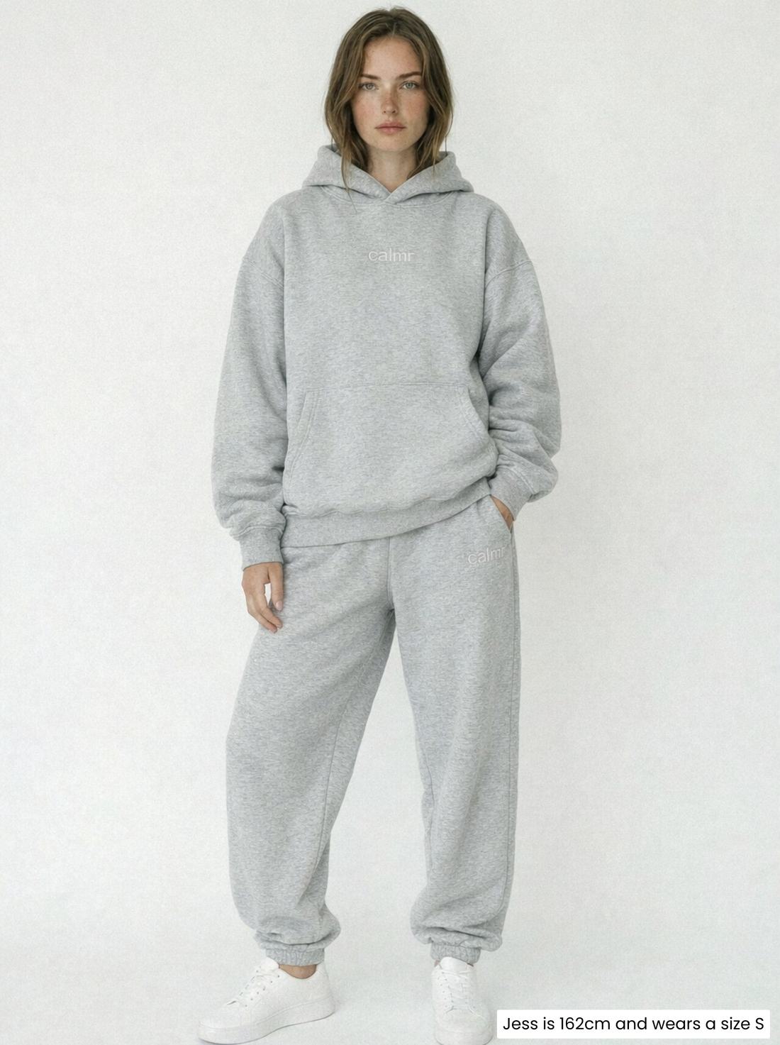 Woman wearing a gray hoodie with 'calm' text on a white background